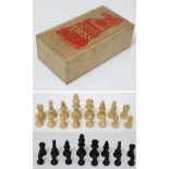A set of boxwood and stained boxwood small chess pieces, housed in a wooden 2 sectional box with red