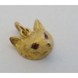 Hunting : A 9ct gold pendant formed as a fox mask with inset red stone eyes 3/8" wide  CONDITION: