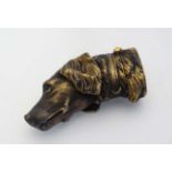 A novelty brass vesta case formed as the head of a dog with striker and hinged lid to one end. 2"