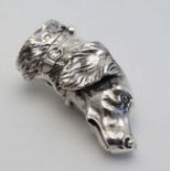 A novelty silver vesta case formed as the head of a dog with striker and hinged lid to one end.