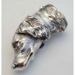 A novelty silver vesta case formed as the head of a dog with striker and hinged lid to one end.