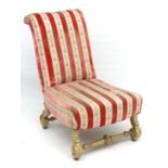 A late 19thC upholstered nursing chair with carved and gilt decorated wooden legs united by fluted