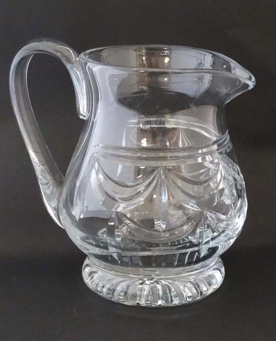 A large cut glass jug with loop handle 9" high  CONDITION: Please Note -  we do not make reference