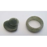 A large green jade ring together with a pendant with Buddha decoration. (2) CONDITION: Please Note -