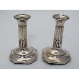 A pair of silver candlesticks with fluted columns on octagonal bases . Hallmarked Birmingham 1909