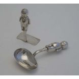 A silver plate Christening set comprising spoon and pusher with handles formed as stylised Kewpie