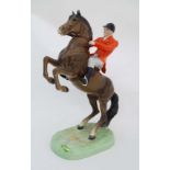 A Beswick figure group of a huntsman in red jacket on a rearing bay horse. Model number 868.