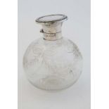 A glass scent bottle of spherical form  with cut and etched decoration  with silver top hallmarked