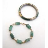 A jadeite bangle with white metal mounts together with a gilt metal bangle set with jade like