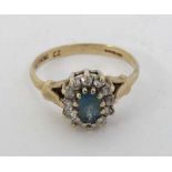 A 9ct gold ring set with central topaz bordered by white stones in a claw setting  CONDITION: Please