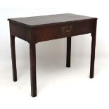 An 18 th C Georgian mahogany side / writing table with single frieze drawer standing on square legs,