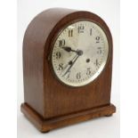 Clock : an Oak cased Arch top 8 day striking mantel clock with movement striking on a coiled gong,