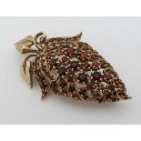 A 9ct gold brooch set with a profusion of garnets 2" long   CONDITION: Please Note -  we do not make