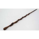 Folkart : a carved wooden walking stick with long brass ferule having the unusual decoration of a