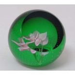 Caithness Scotland:  A glass paperweight of green and clear glass with pink rose to centre