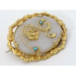 A gilt metal brooch set with chalcedony oval with applied gilt and turquoise detail 1 1/2" wide