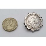 A brooch with Victorian one shilling 1896 coin to centre within a white metal captive mount . The