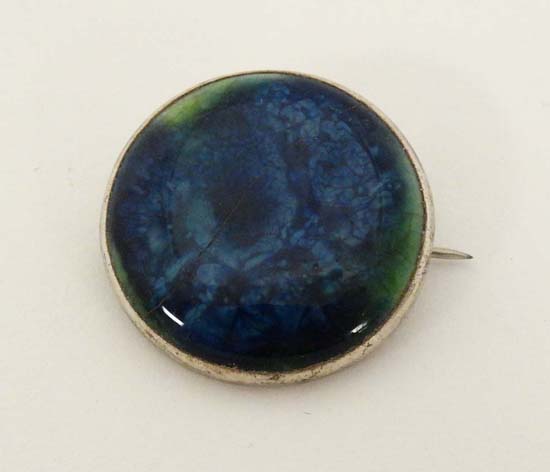 Ruskin Pottery: A white metal brooch set with Ruskin pottery cabochon . Marked Ruskin England to