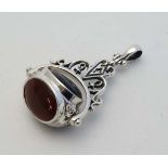 A silver pendant fob with central rotating section set with various hardstone seals. 1 1/2" high