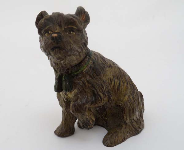 A hand painted cast bronze figure of a sejant terrier dog with tasseled collar and hinged head 3 1/