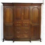 Maple & Co Ltd London & Paris : An oak cross banded break-front wardrobe having central cupboard