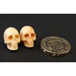 Two old carved coral skulls , each approximately 5/8" high  CONDITION: Please Note -  we do not make