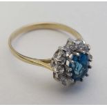 A 9ct gold ring set with central topaz coloured stone bordered by white stones in a claw setting