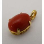 Coral pendant with gilt metal : an indistinctly marked interior hanging ring with a cabachon coral