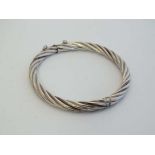 A white metal bracelet of bangle form with safety chain.  CONDITION: Please Note -  we do not make