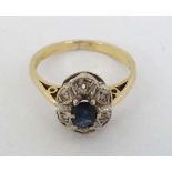 An 18ct gold ring set with central sapphire bordered by diamonds  CONDITION: Please Note -  we do