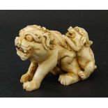 Netsuke : a 19 thC Japanese hand carved Netsuke in the form of a Dog of Foo and a baby , 2 1/8" long