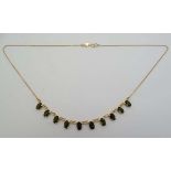 An 18ct gold necklace set with 10 green tourmaline drops .  16" long  CONDITION: Please Note -  we