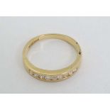 An 18ct gold ring set with 9 channel set diamonds  CONDITION: Please Note -  we do not make