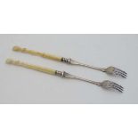 A pair of silver plate pickle forks with bone handles formed as deers hooves approx 8 1/2"