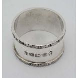 A silver napkin ring with banded decoration and hallmarked for Sheffield 1977 maker Cooper