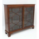 An early 19thC mahogany bookcase with astral glazed twin doors, shaped bracket feet and adjustable