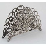 A white metal letter rack / napkin holder with floral and C scroll decoration. 2 3/4" high x 4" wide