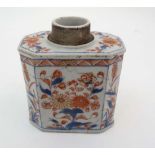 A Chinese tea caddy with blue , red and gilt floral and foliate decoration on a white ground.