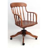 A c.1900 American turned spindle back tilt and swivel office armchair with flattened arm supports