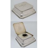 Golf Interest : A silver desk top inkwell of squared form with hinged lid and glass liner within.