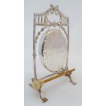 A silver plate table gong with bow and harebell decoration and beater. The whole 13 1/2" high