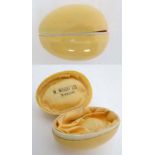 A celluloid ivory like novelty ring box formed as an egg form marked ' W Wright Jewellers ' within 2