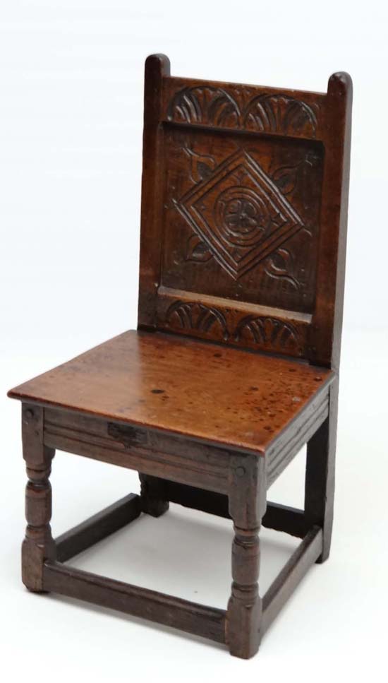 A 17thC carved oak solid seat single chair with panel back . 33" high x 17 3/4" wide x 15" deep