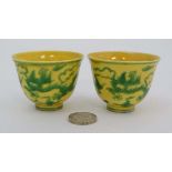 A pair of small Chinese Imperial yellow bowls decorated with green five clawed dragons. With