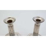 A pair of silver candlesticks with fluted columns on octagonal bases. Hallmarked Birmingham 1909