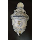 A c1901 Delft style ceramic wall hanging water cistern with lid. Decorated with an image of a cherub