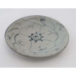 A small Chinese blue and white ceramic plate. Loosely decorated in an Oriental style. 5''