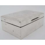 A silver table top cigarette box with engine turned decoration and wood lined interior. London