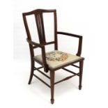 An Edwardian mahogany open arm chair with upholstered seat, squared tapering legs and spade feet 31"