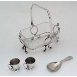 A silver plate sugar basket with cut glass liner and swing handle together with a silver plate caddy